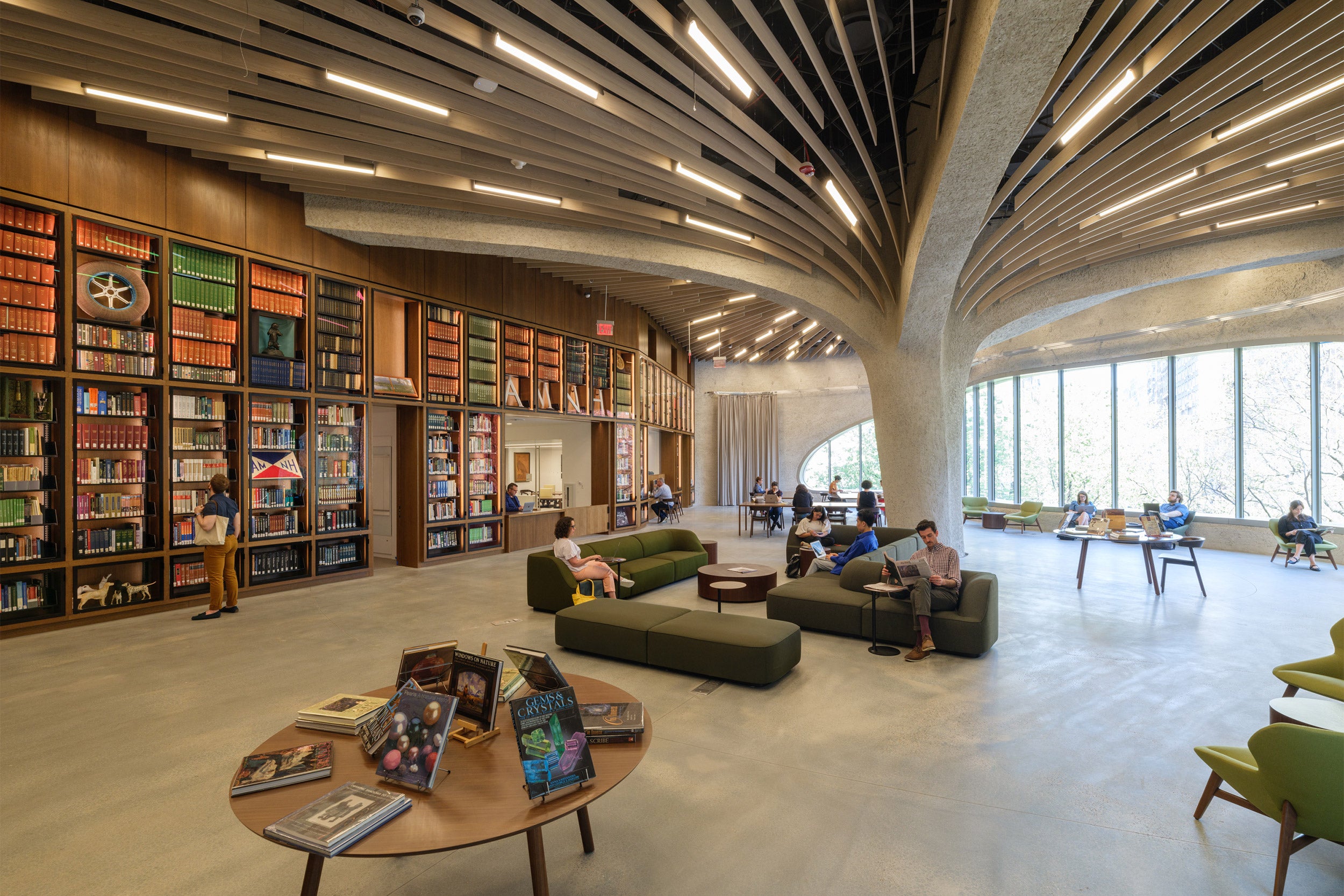 View of sunny, spacious Gilder Center library's mushroom like ceiling with large column.