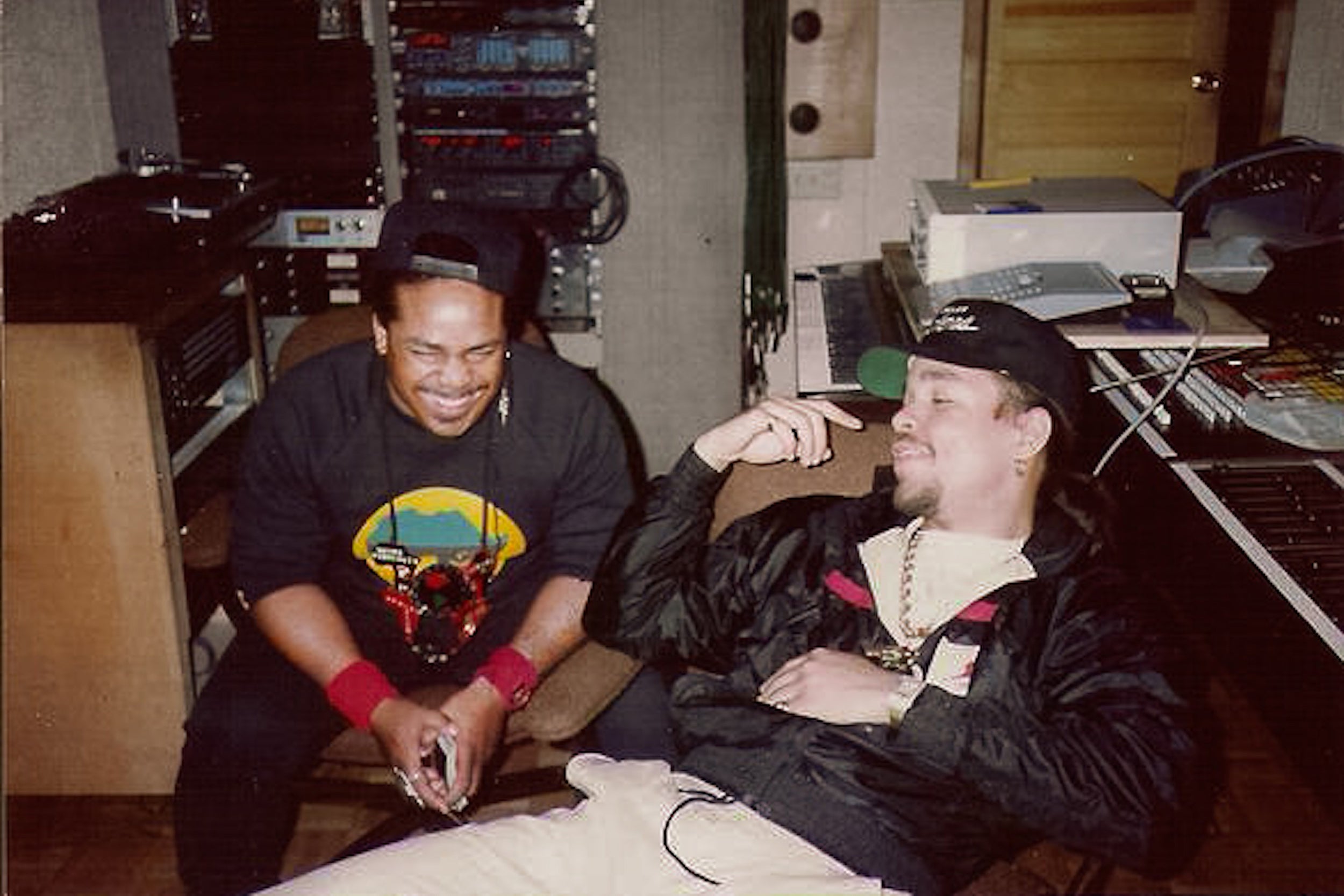 Ice T and Afrika Islam laugh together in studio in image from 1980s.