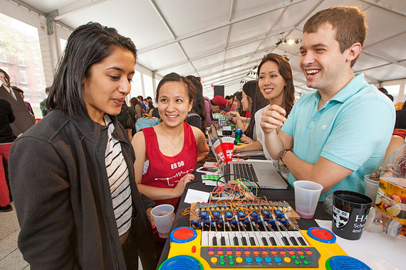 Ha Le '14 (in red) and Eric Hendey '14 show off their ES 50 project, which converts music files into simple outputs and mechanically plays them on a keyboard.