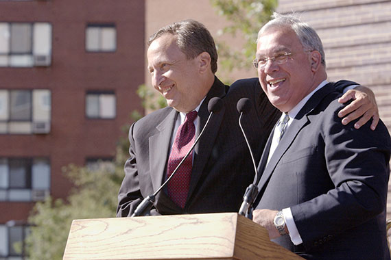 Former Harvard President Lawrence H. Summers and Boston Mayor Thomas M. Menino shared a friendly embrace in 2003 at the grand opening of graduate housing at One Western Avenue. File photo by Stephanie Mitchell/Harvard Staff Photographer