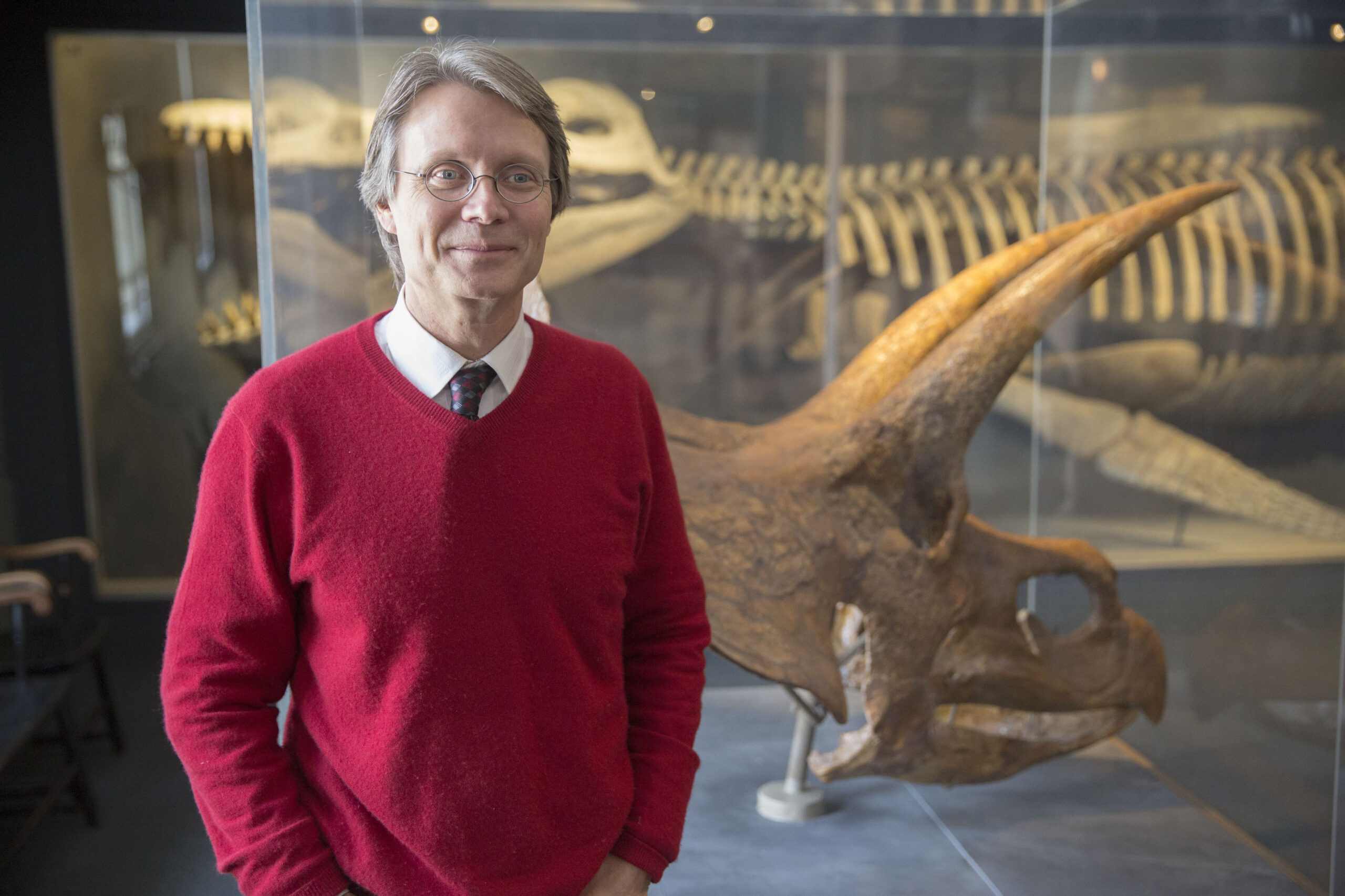 A professor in front of dinosaur bones