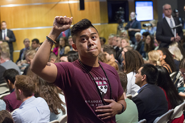 HGSE student Tony Delarosa raises a fist in protest as Betsy DeVos speaks.