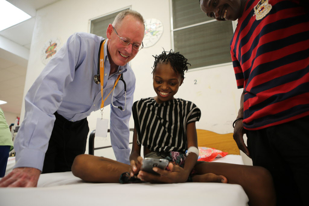 Dr. Paul Farmer speaks with 12-year-old being treated for jaundice at University Hospital in Haiti.