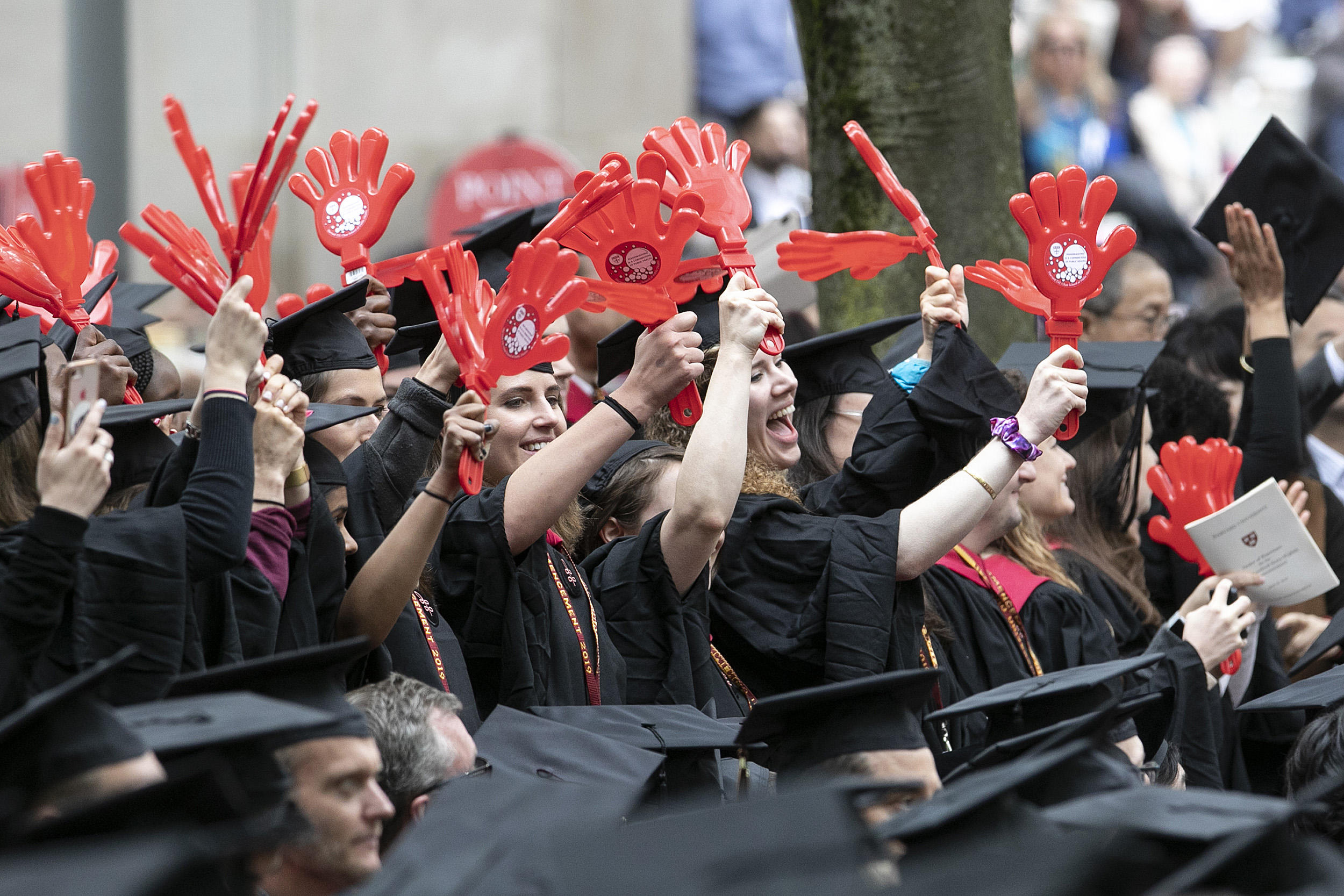 Harvard T.H. Chan School of Public Health graduates wave with red plastic clappers