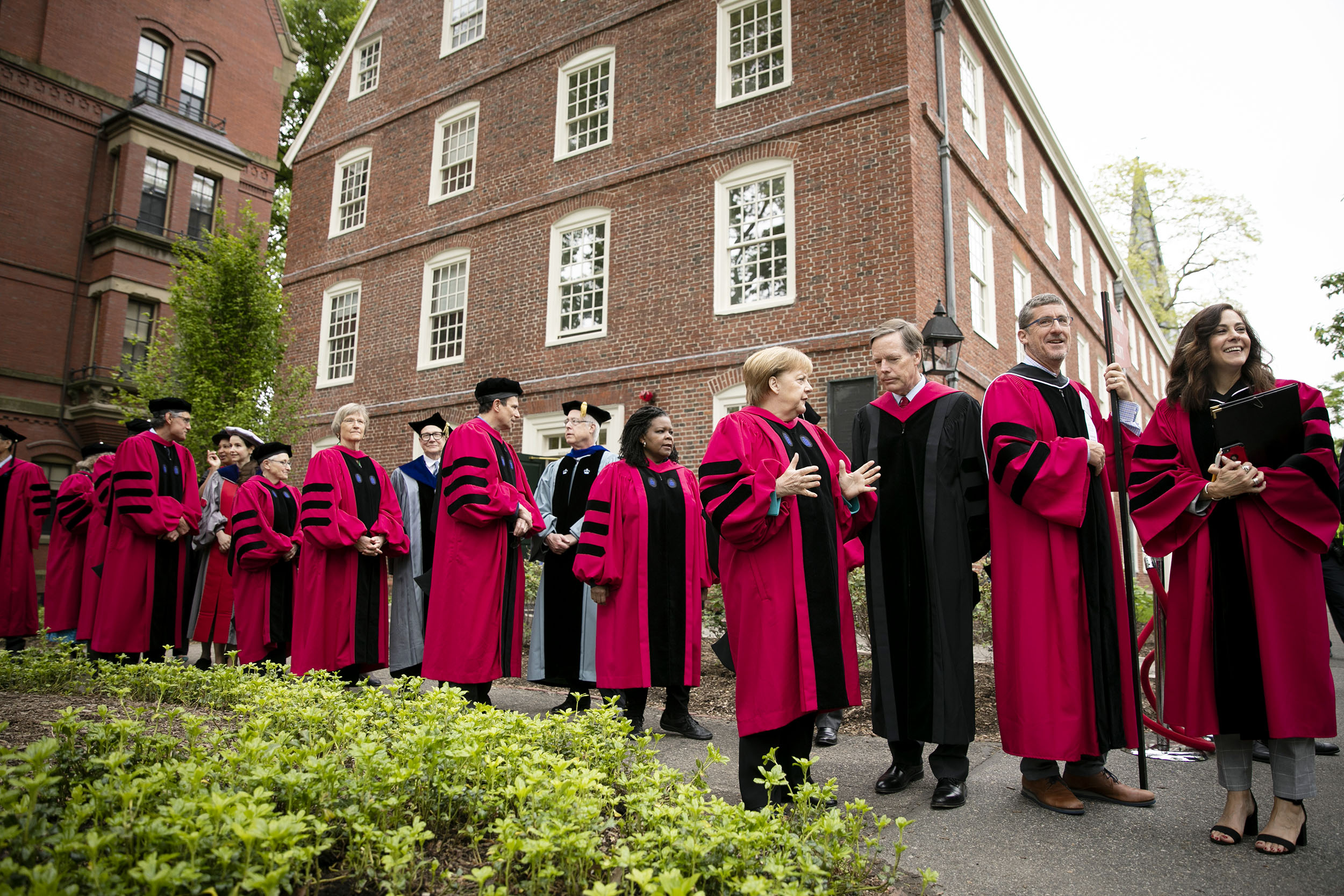 Honorary degree recipients and their escorts line up outside Massachusetts Hall.