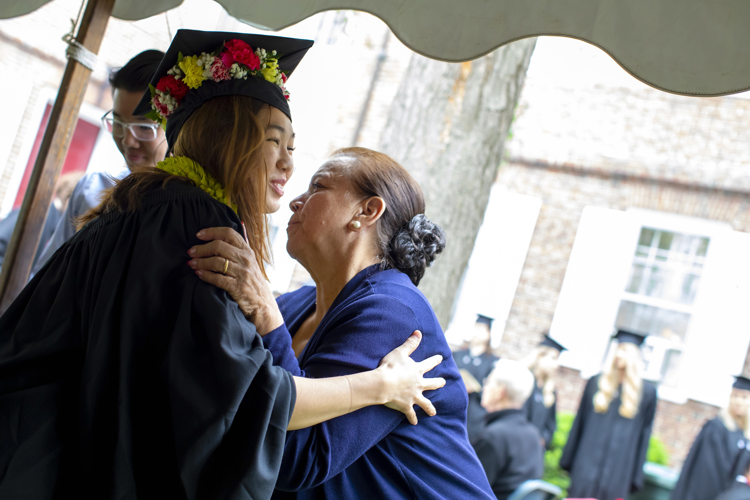 Moriah Lee hugs her grandmother Joleen Cordeiro who decorated her mortarboard with a lei.
