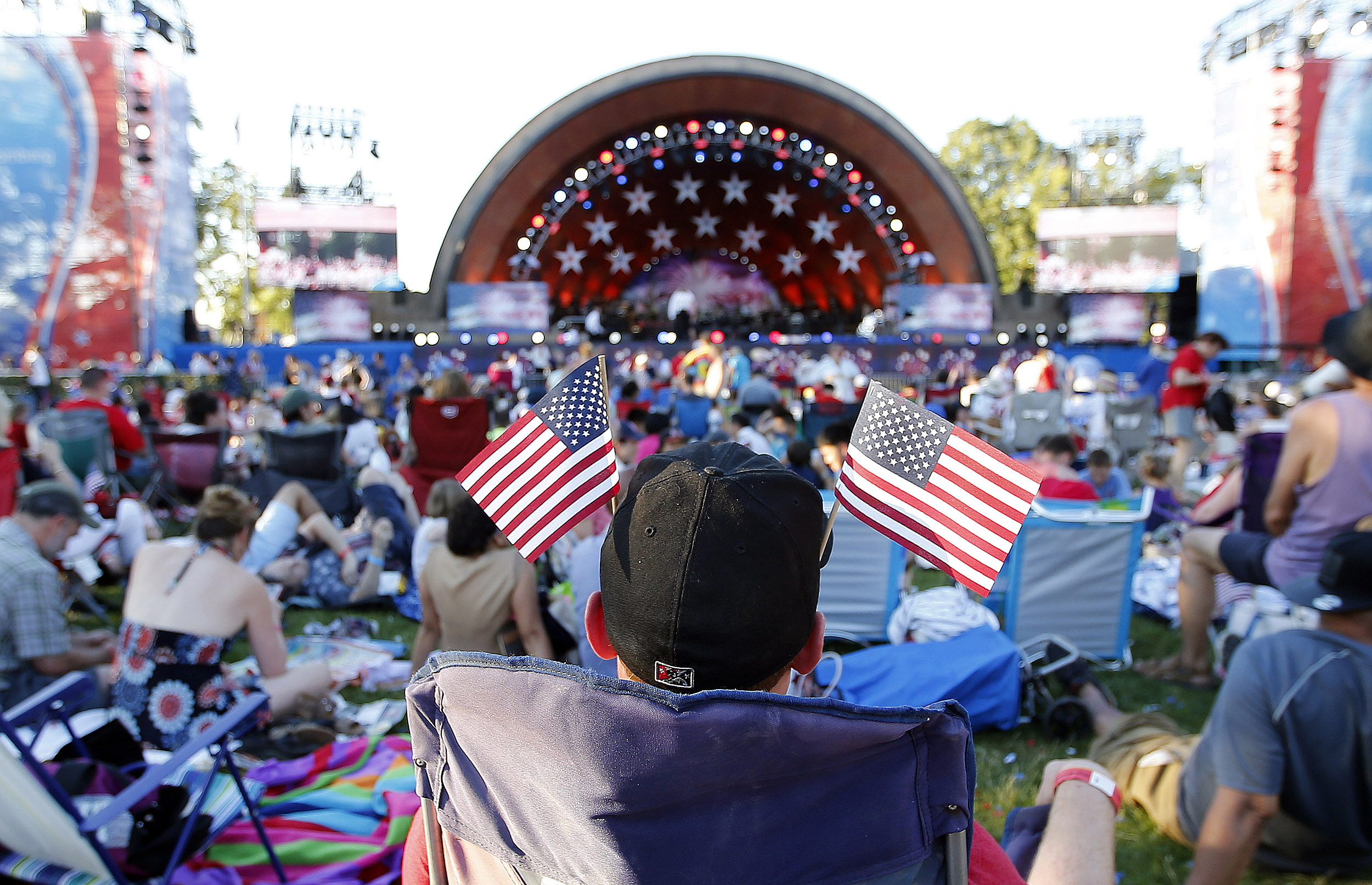Man with American flags in his baseball cap, facing the Hatch Shell