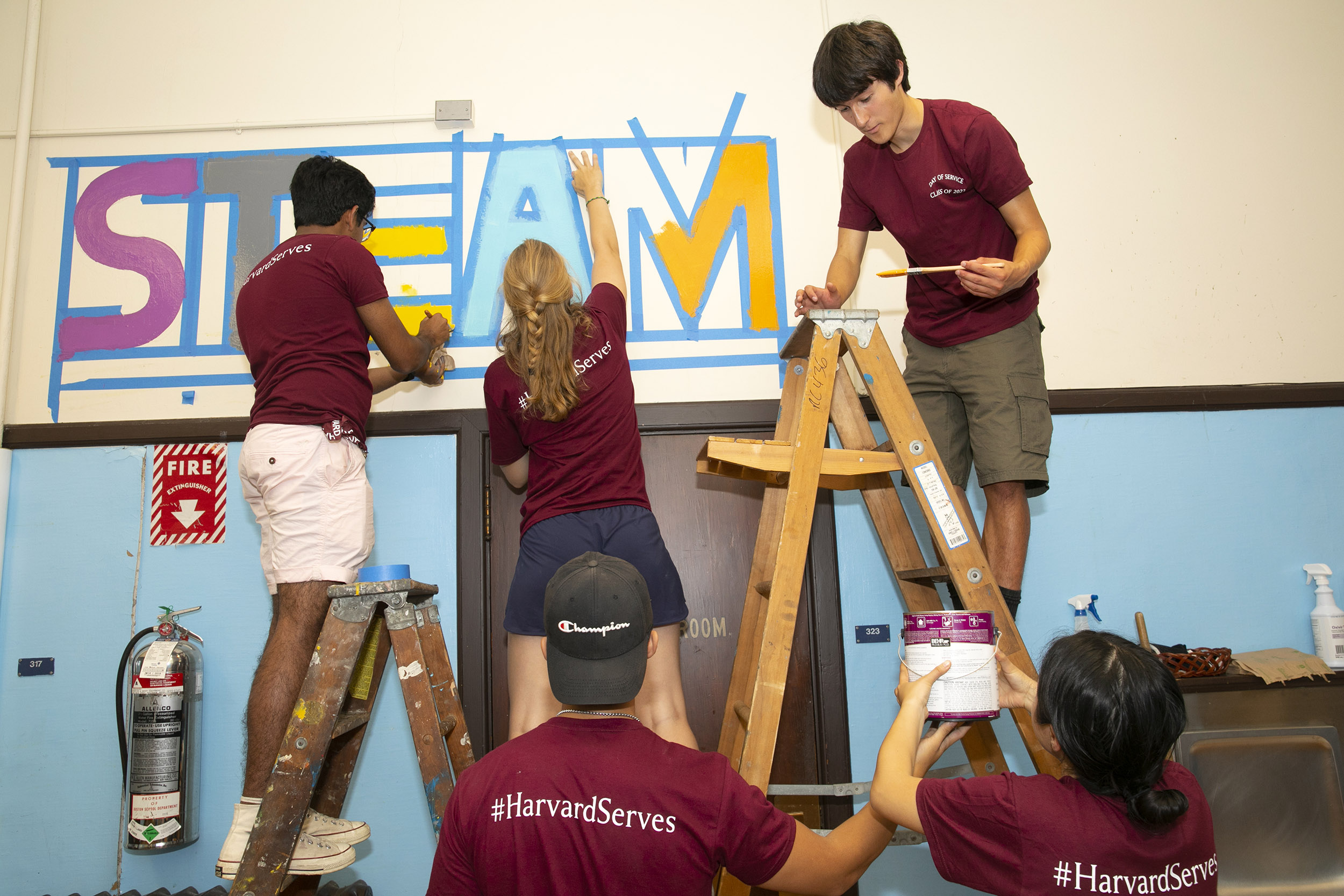Students painting inside a gym