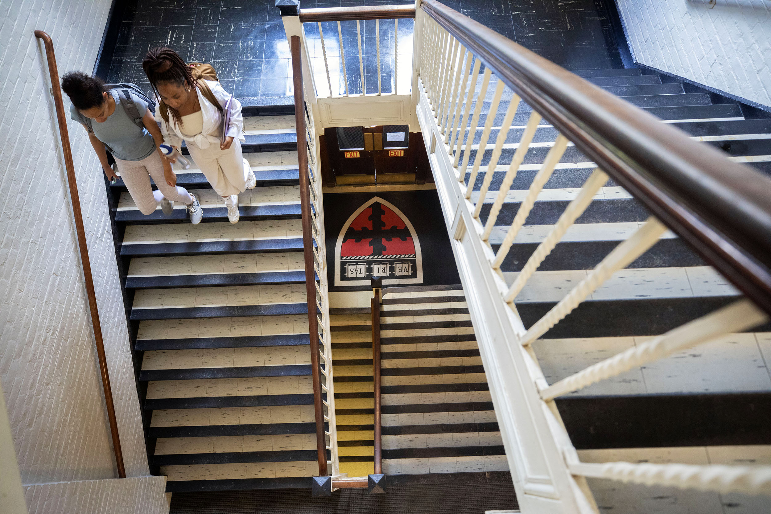 Two students walk down stairs in Pierce Hall.