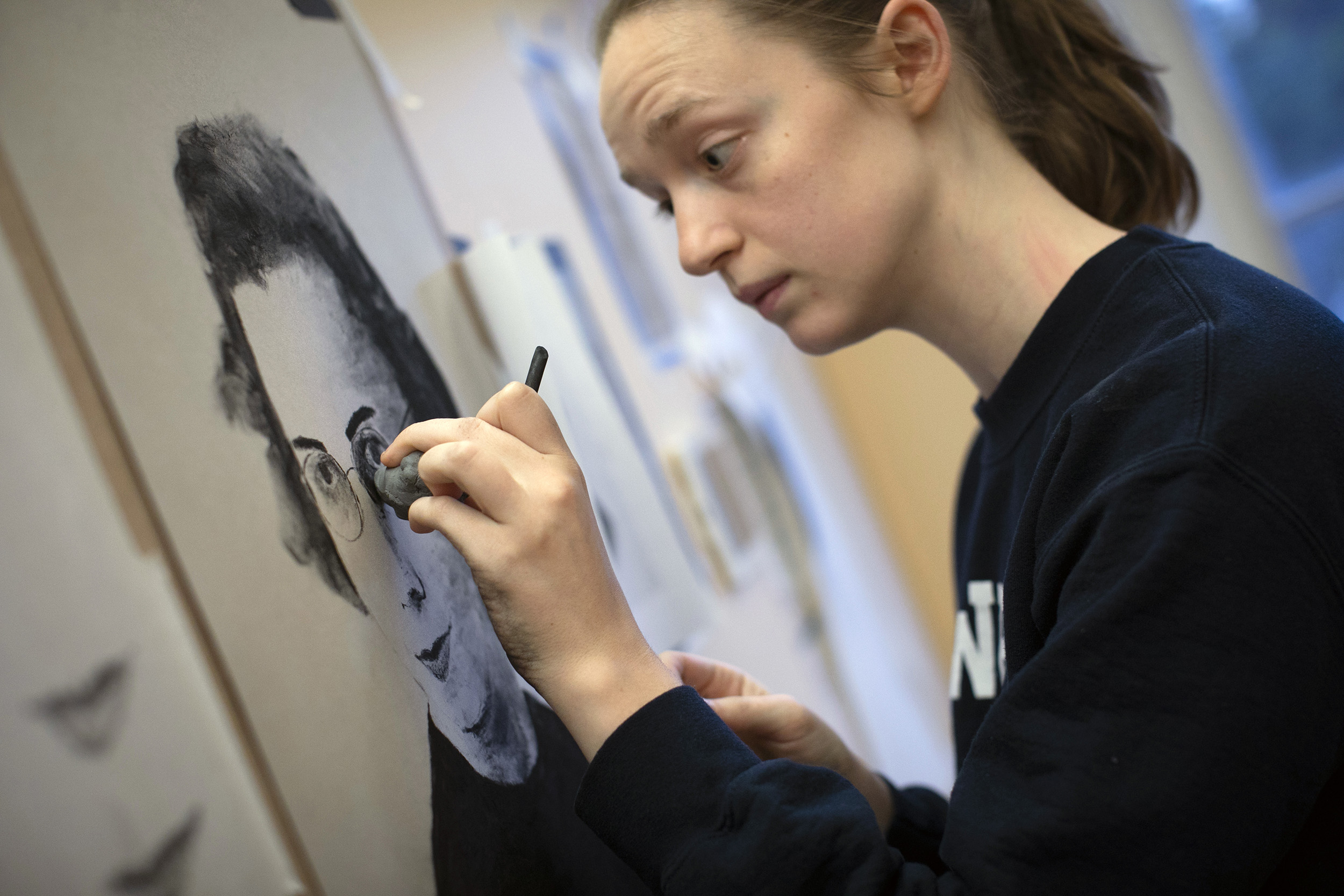 Becky Jarvis draws her grandmother using charcoal.