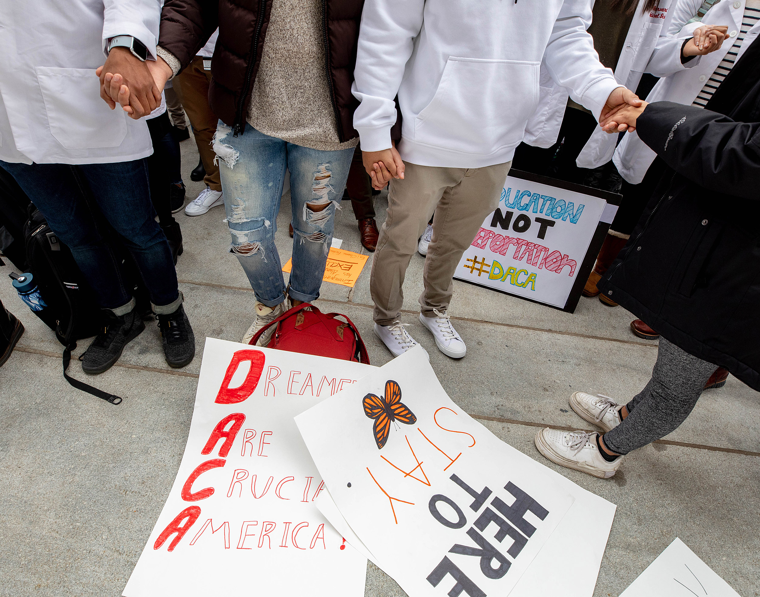 People holding hands over posters