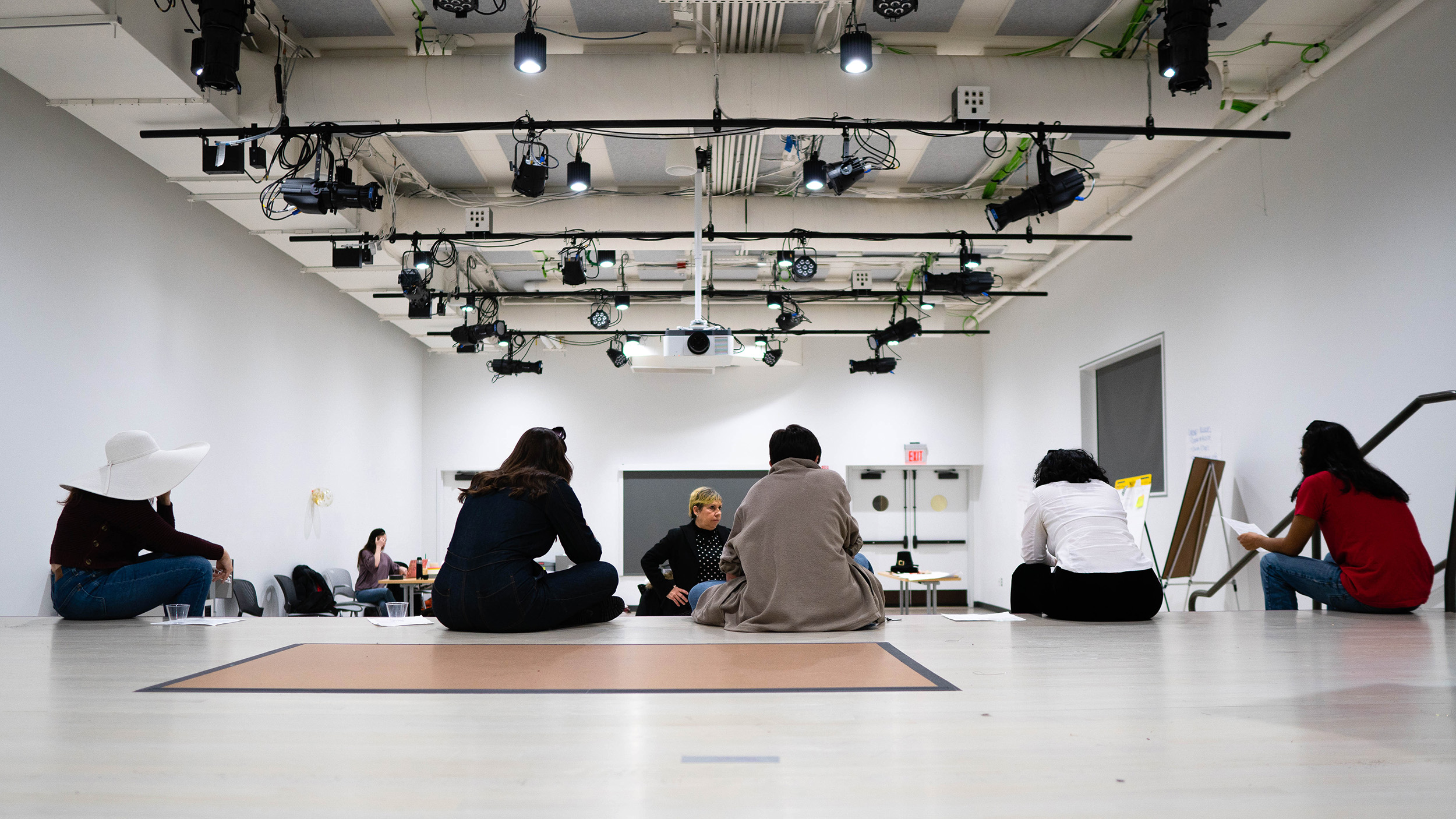 Performers sit and take a break on the stage.