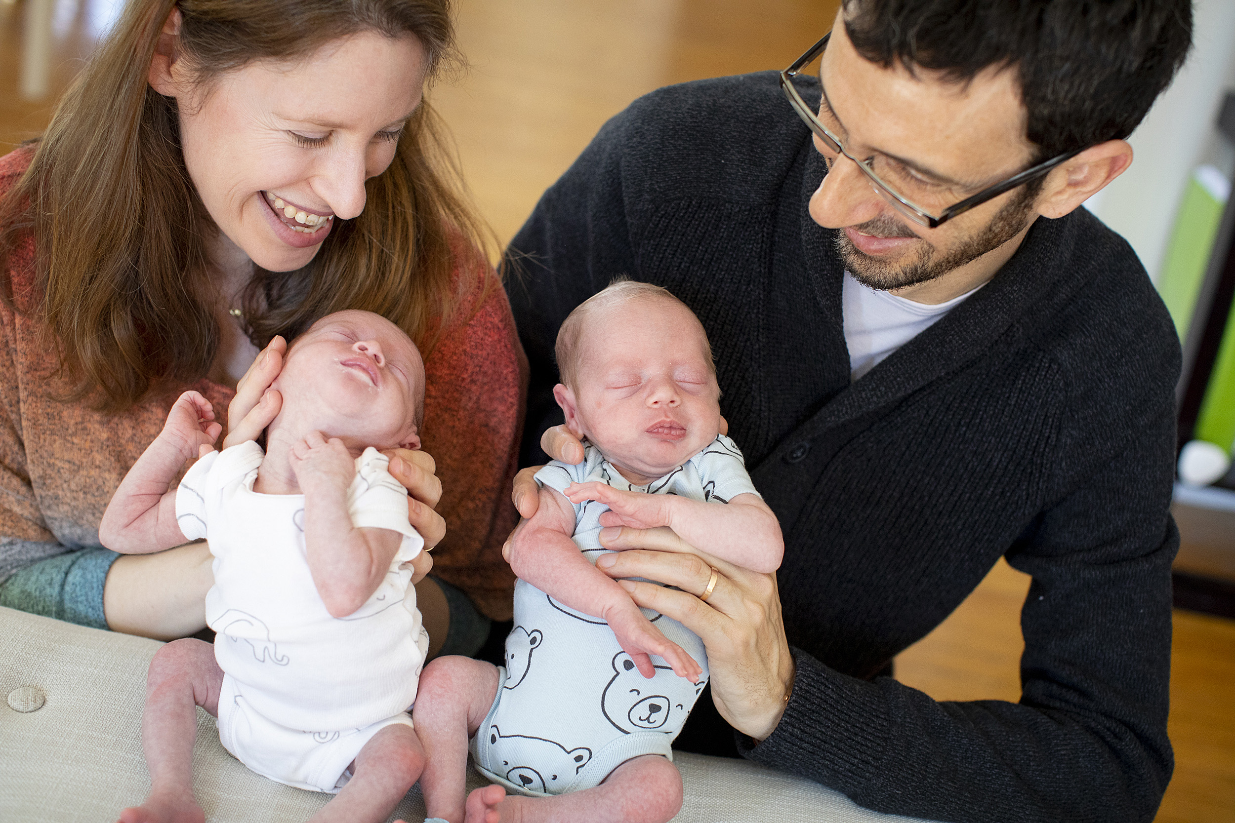 Parents hold newborn twins.