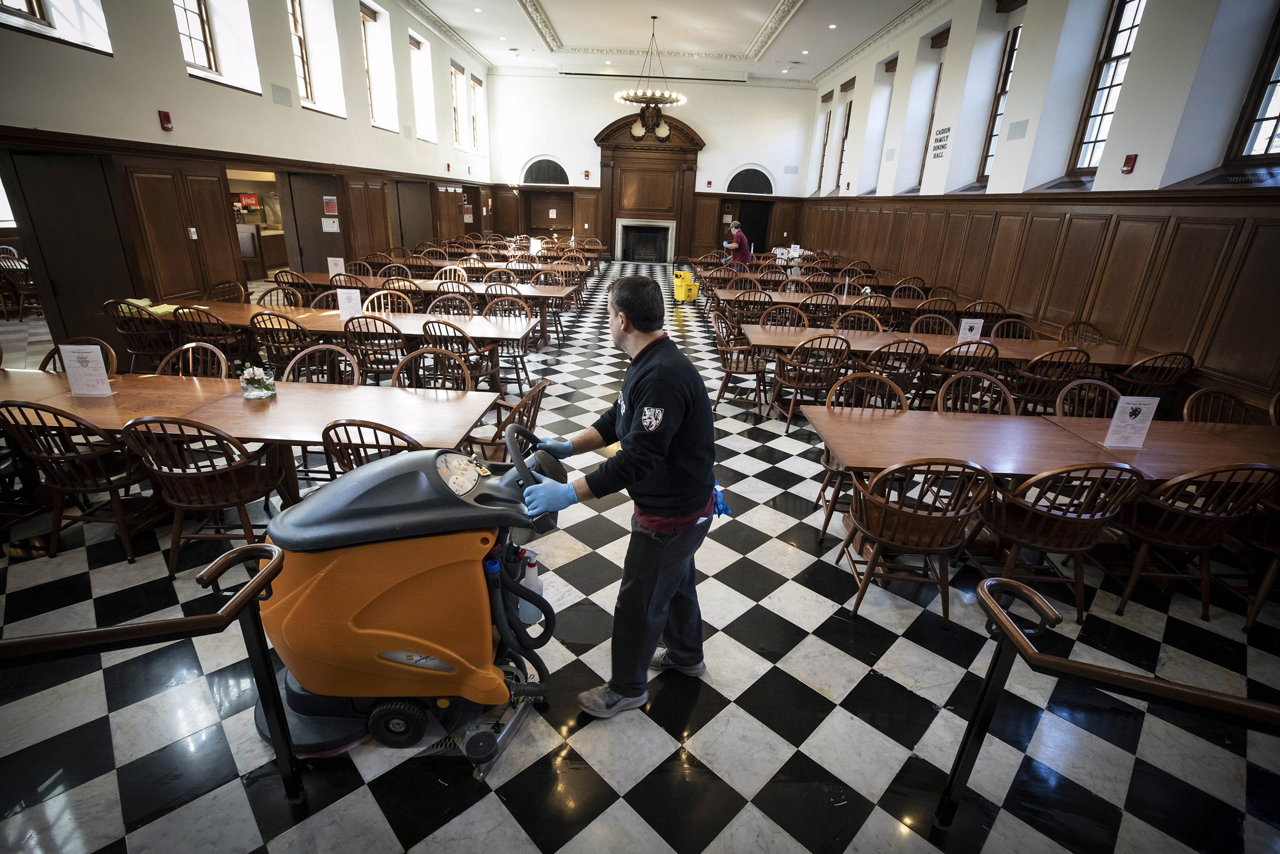 Custodian cleaning dining room.