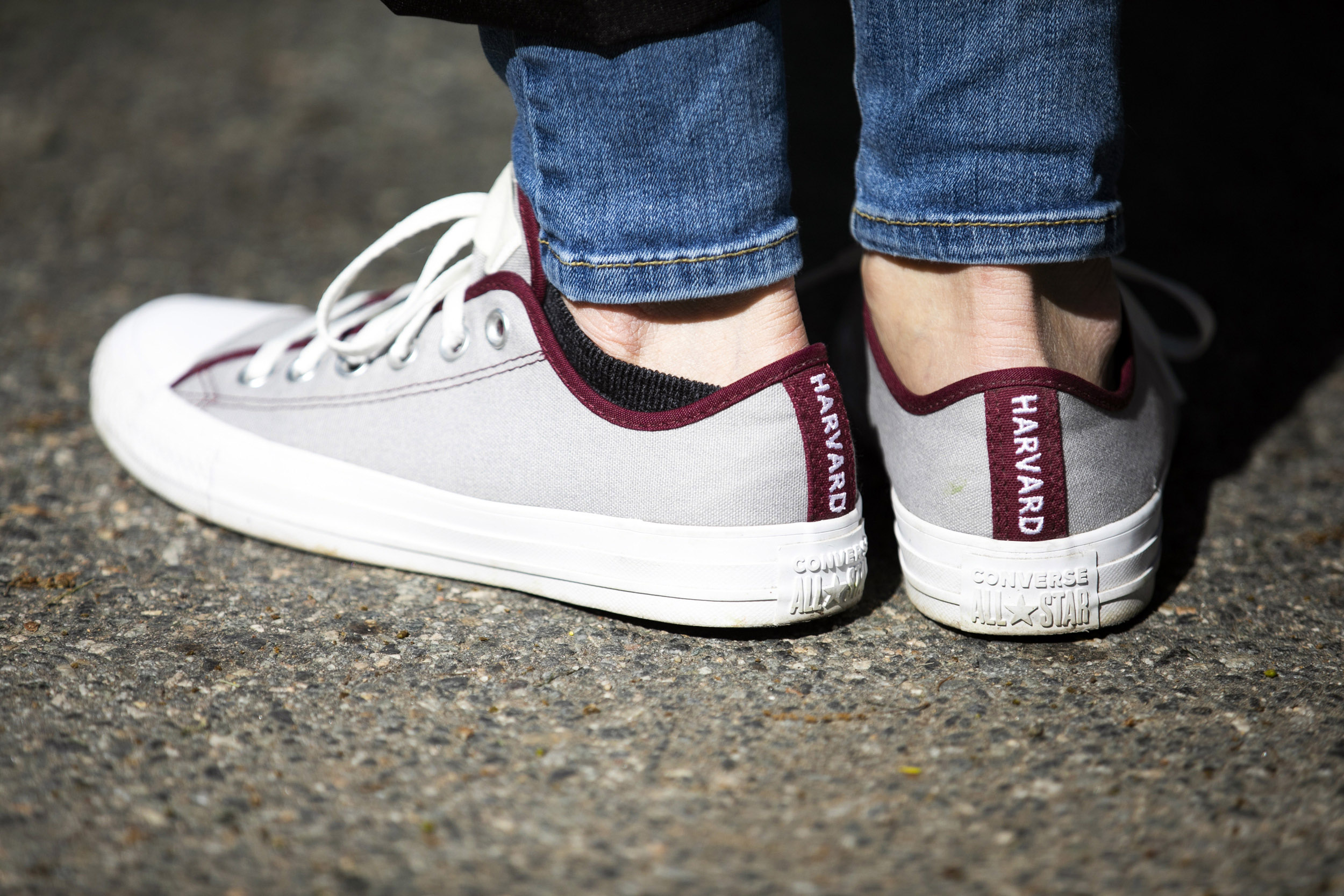 Converse sneakers that read Harvard along the back.