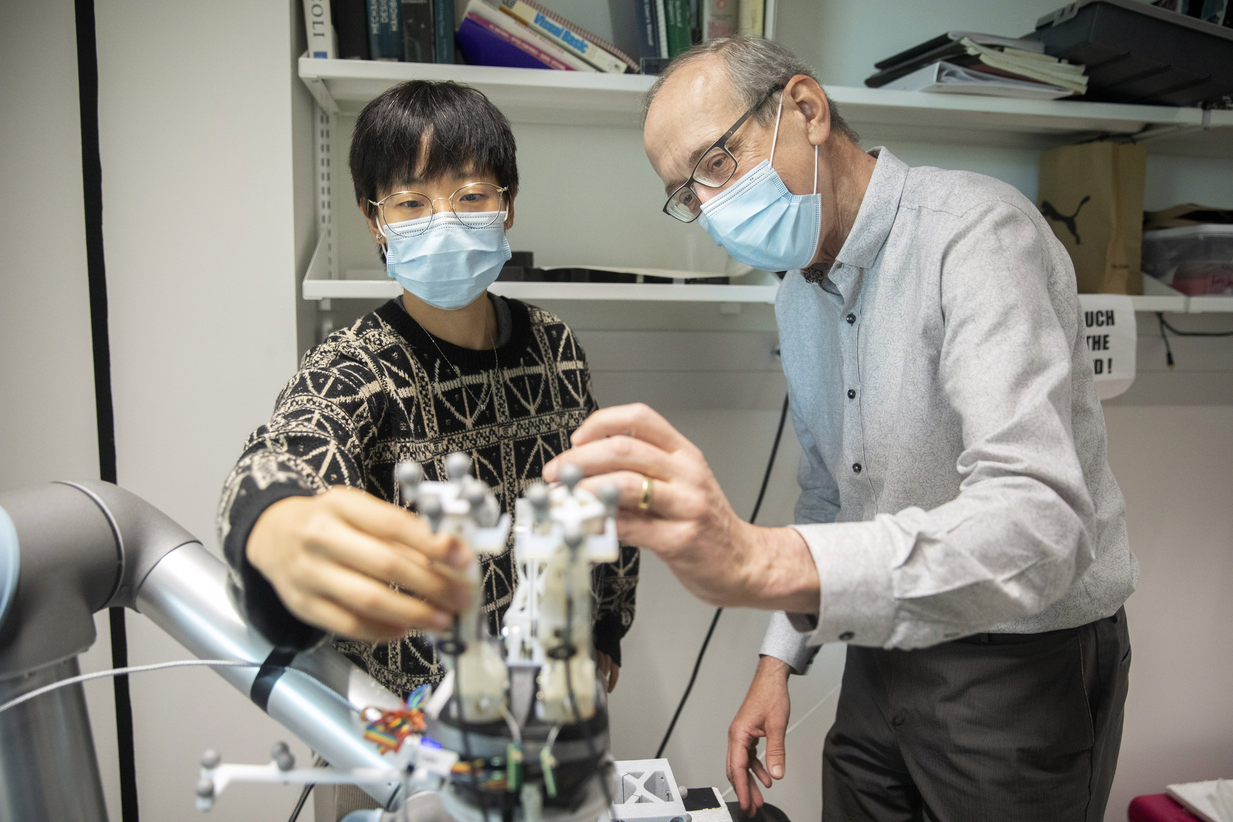 Research assistant Zeo Liu (left) and Robert Howe, Abbott and James Lawrence Professor of Engineering at SEAS, work with robotic hands in the Harvard Biorobotics Laboratory.