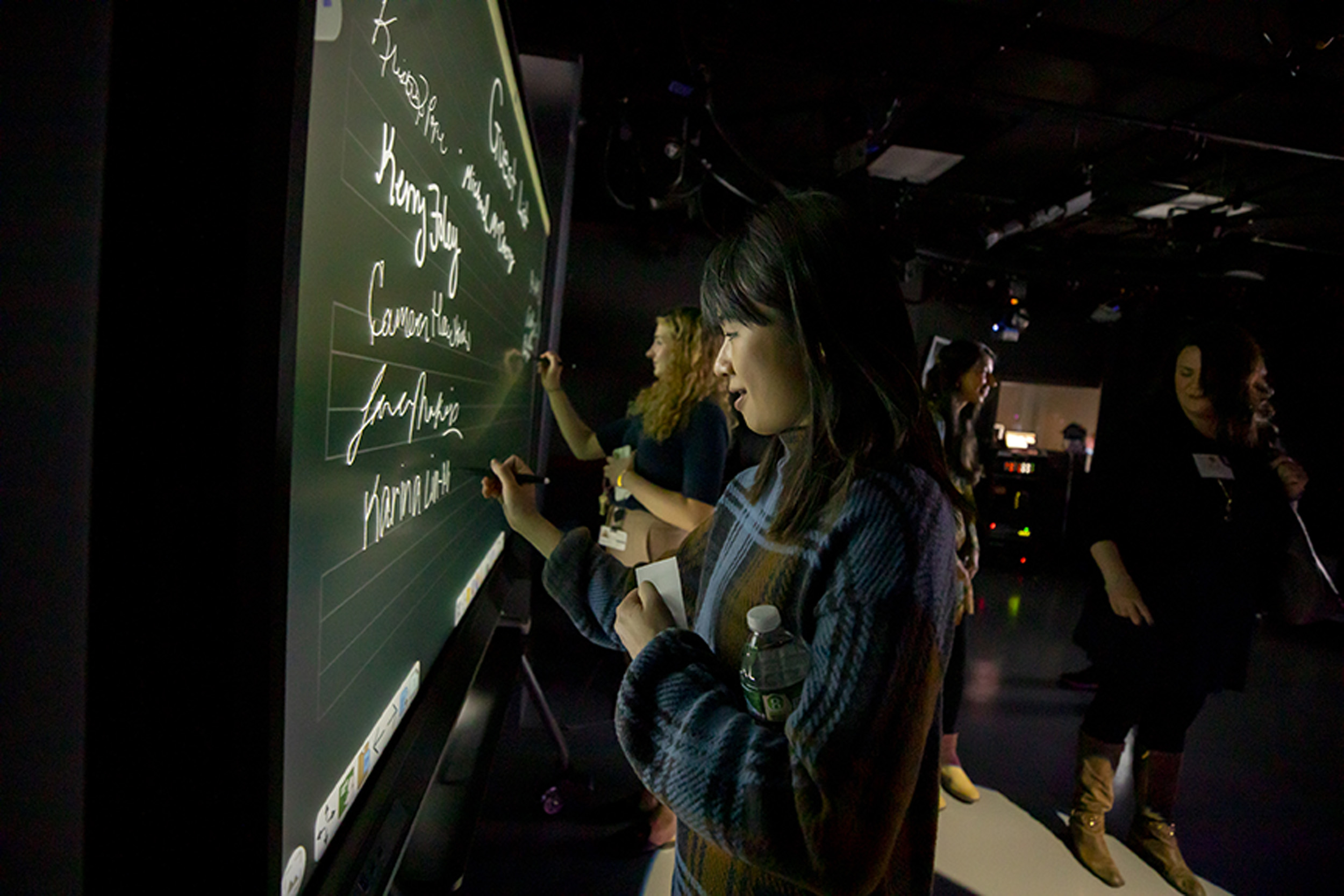 Karina Lin-Murphy writes her name on the welcome board in the new tv studio