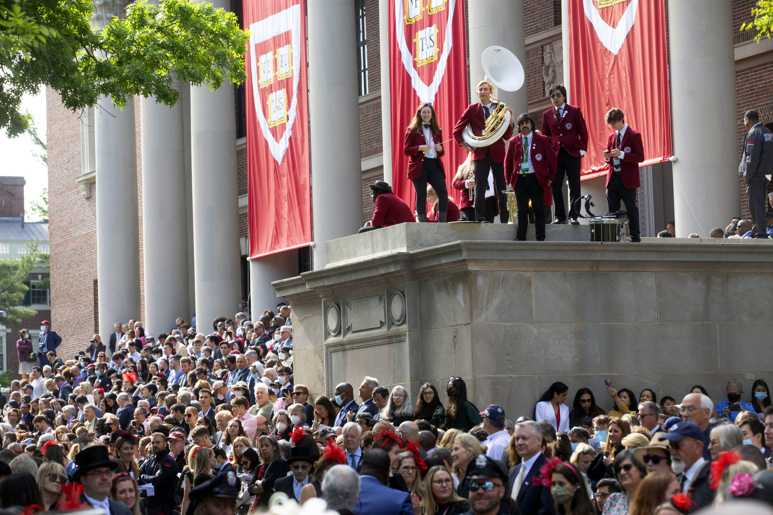 The Harvard Band gathers at Widener Library with a sea of family members below.
