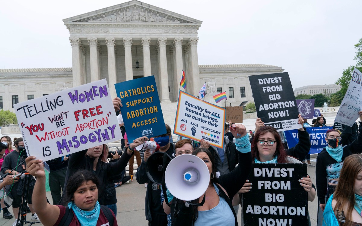 Demonstrators hold signs for and against abortion rights outside Supreme Court.