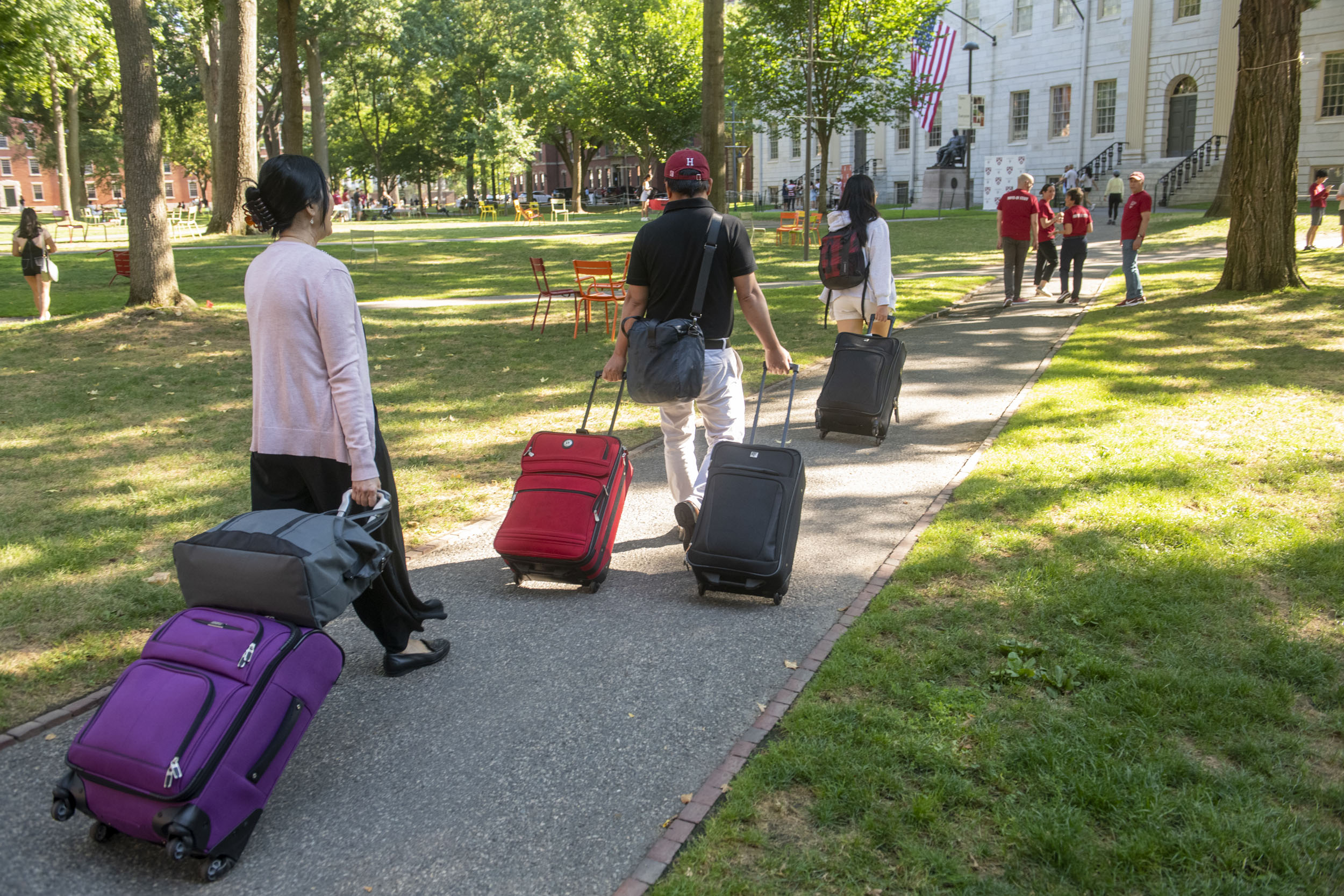 Students bring suitcases into the Yard.