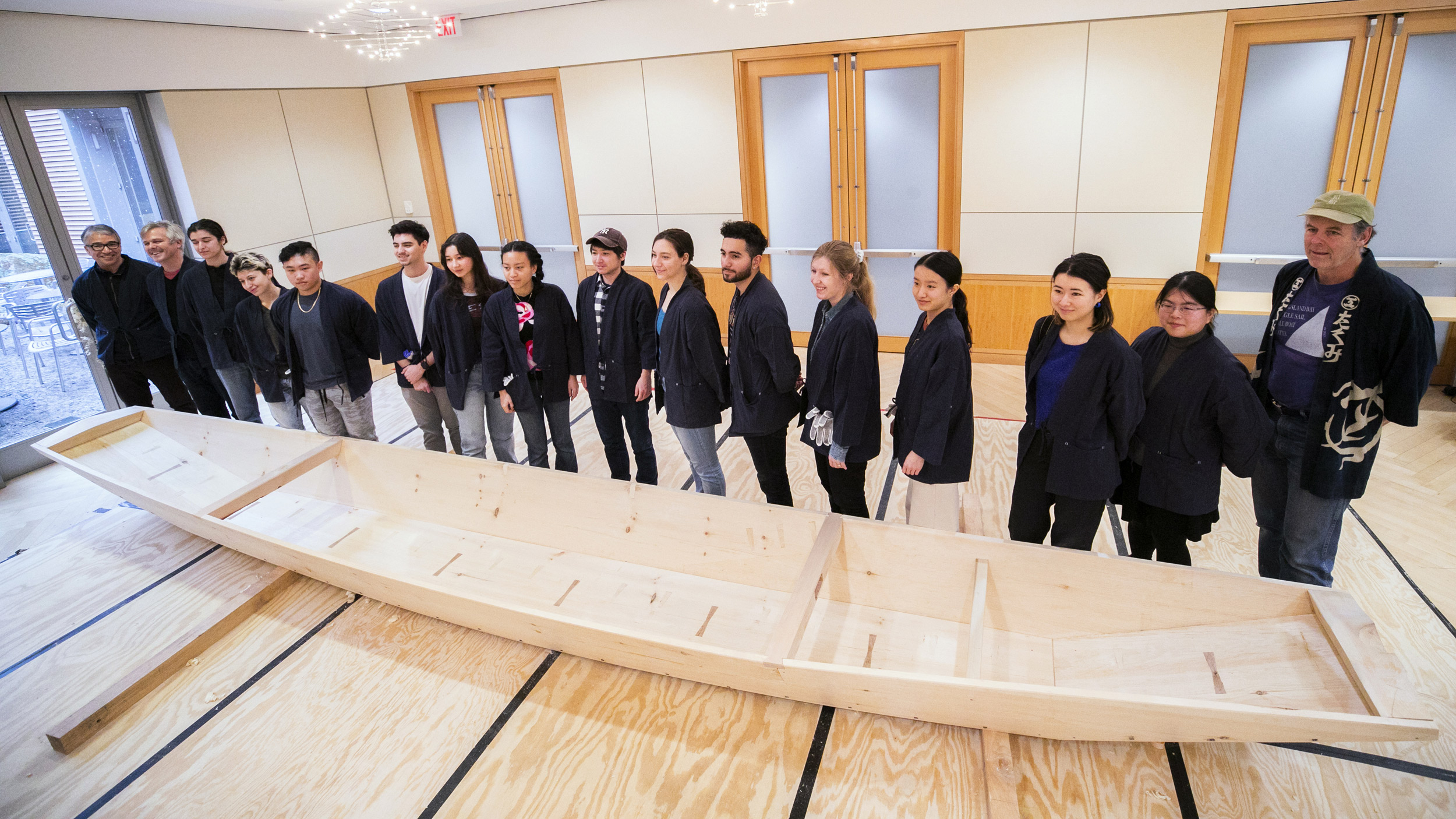 Students, Brooks, and members of the Reischauer Institute, who made the project possible, pose with the completed riverboat in the classroom workshop.