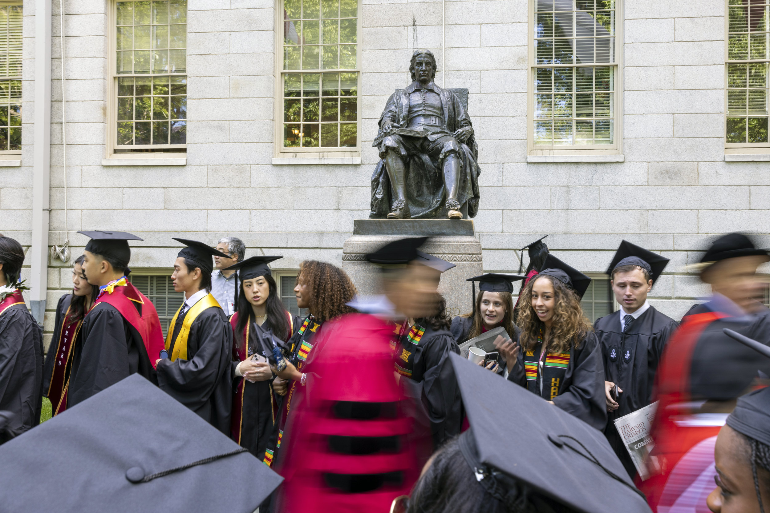 Graduates stream past John Harvard Statue on way to Tercentenary Theatre.