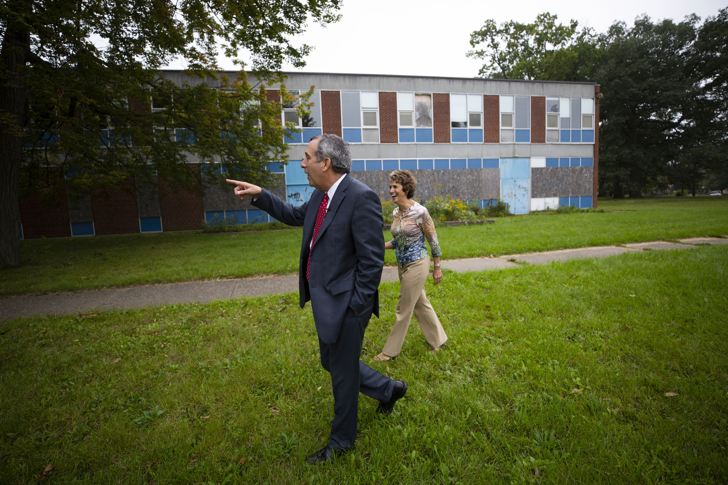 Bacow walks the grounds of one of his former schools with his wife.