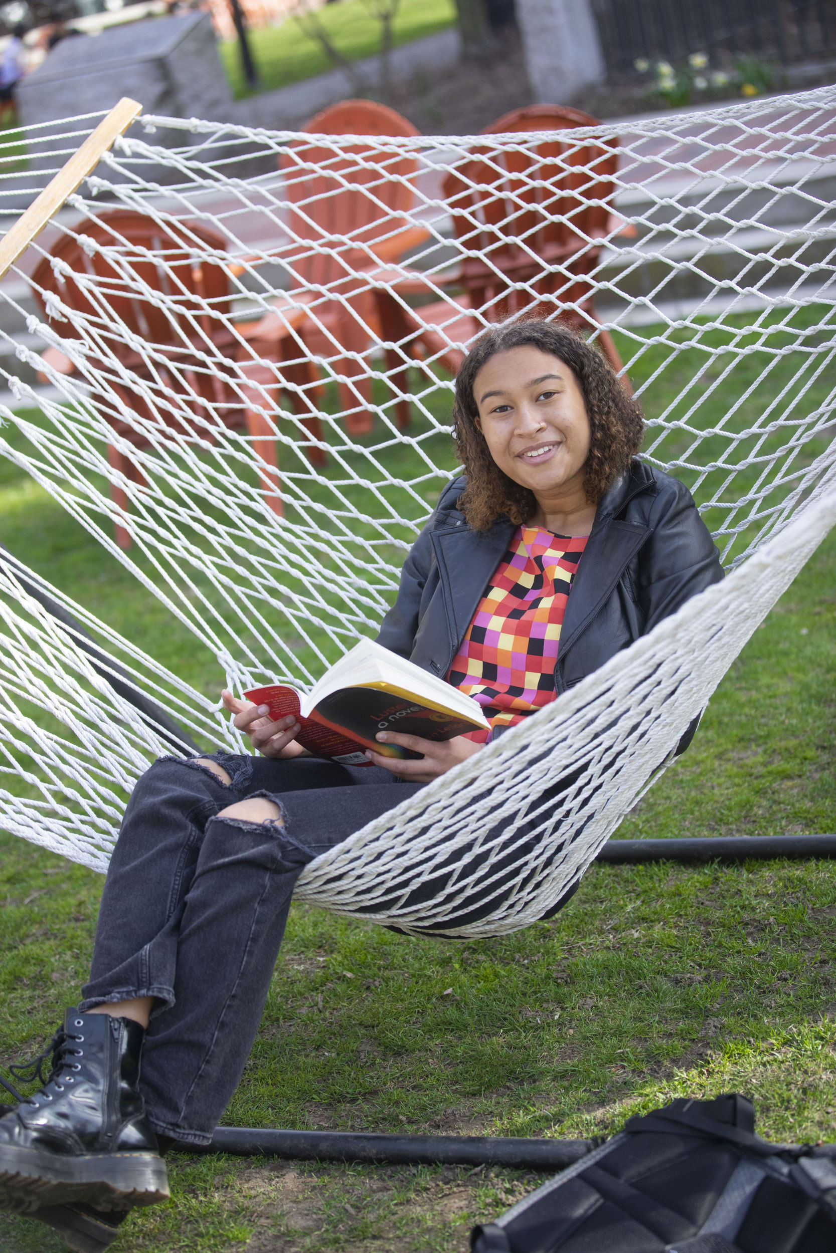 Maya Woods-Arthur ’23 studies a book while on a net hammock.