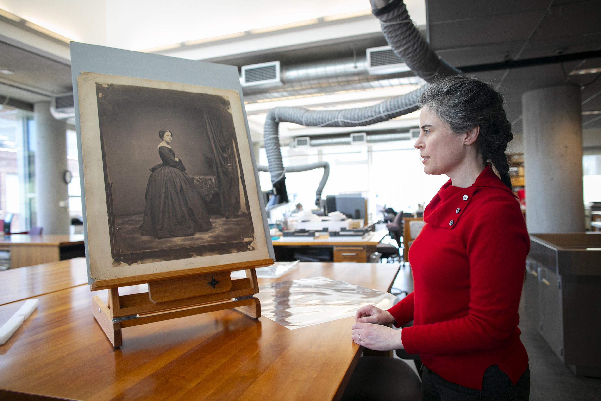 Amanda Maloney looks at a salt print propped up on an easel in the Weissman Preservation Center.