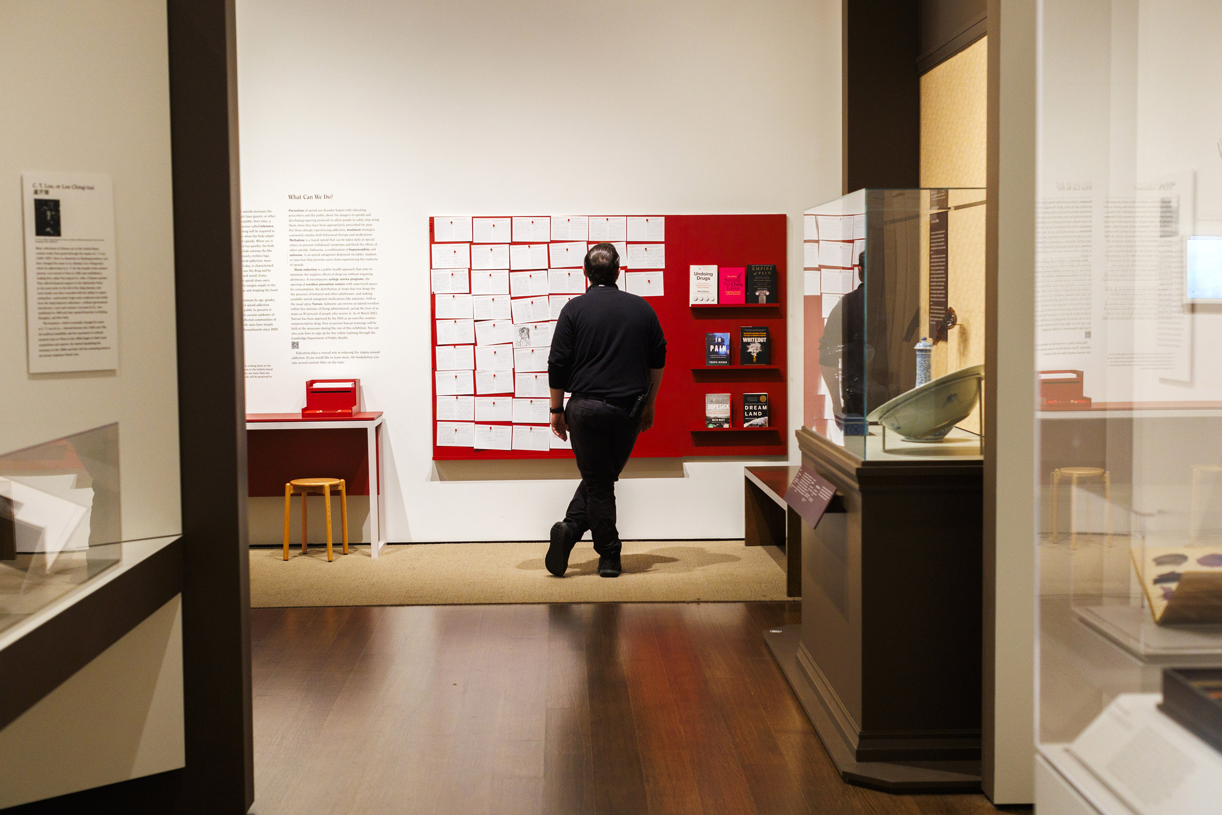 A person is pictured reading the comments written in the exhibition at Harvard Art Museums.