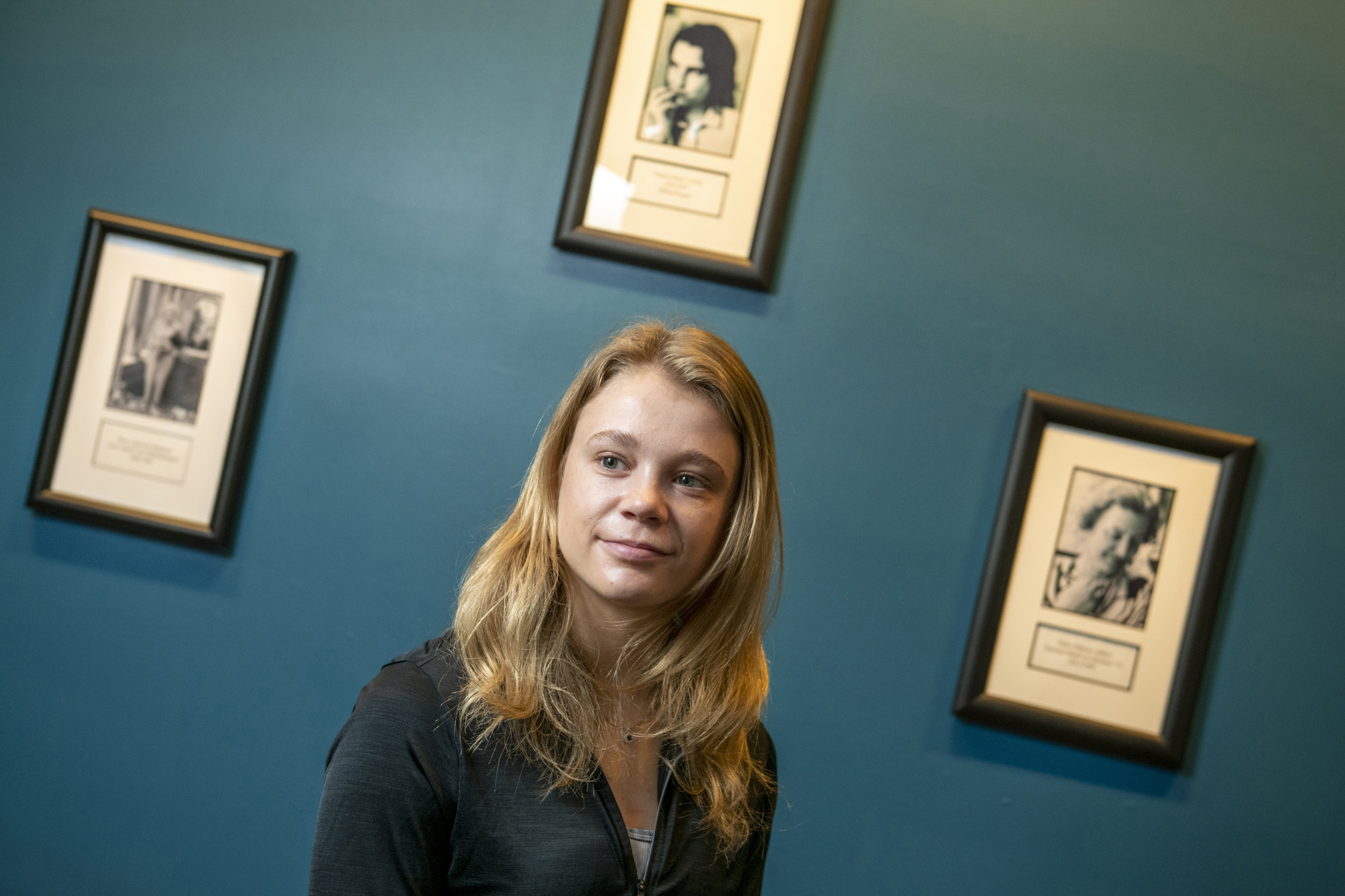 Morgan Sokol ’24, framed by portraits of eminent Currier House women, is running this year’s Boston Marathon.