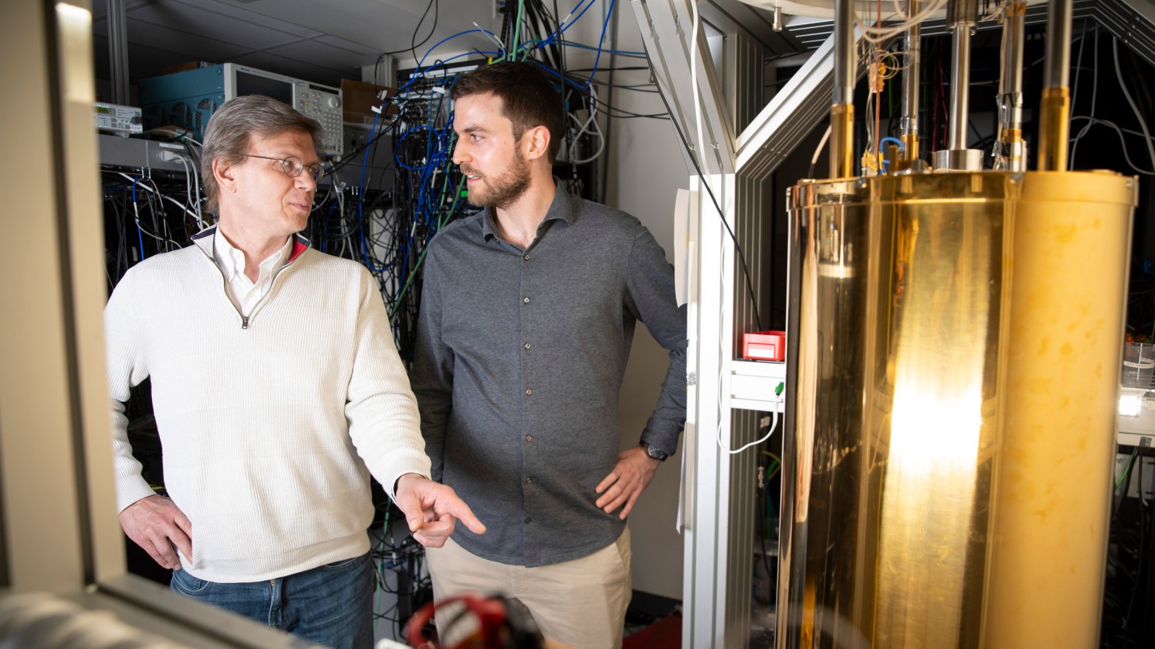 Mikhail Lukin (left) and Can Knaut stand near a quantum network node called a diamond silicon vacancy center.