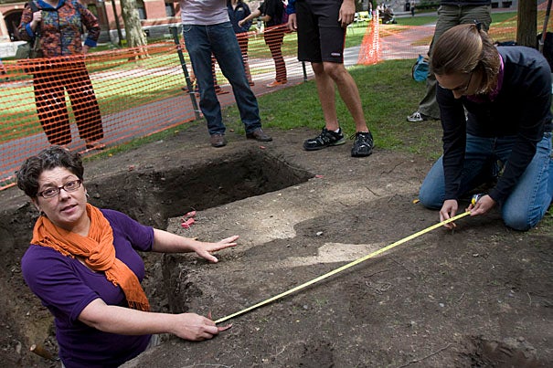 Associate Curator Diana Loren (left) and Senior Curatorial Assistant Christina Hodge at the dig site in front of Matthews Hall where “The Archaeology of Harvard Yard” class continues its work uncovering the College’s roots.