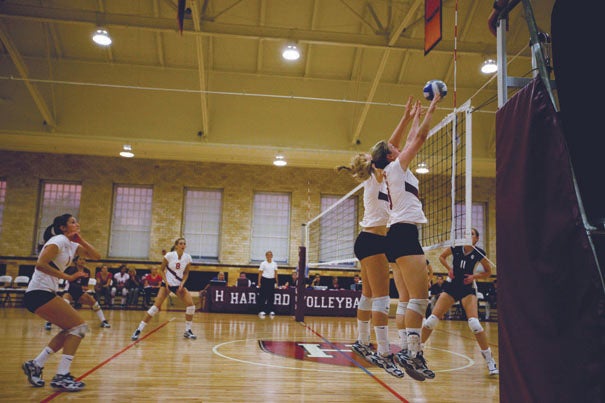 Two Crimson players go up for the block in Harvard's 3-2 loss to UConn.