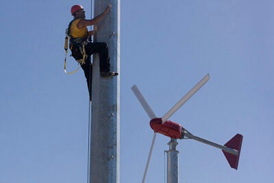 Thomas Dowd, owner of North Shore Solar and Wind Power, installs one of the twin turbines on top of Harvard’s Soldiers Field Parking Garage. Each turbine is rated at 10 kilowatt-hours, which represent the University’s largest wind energy project on campus to date.