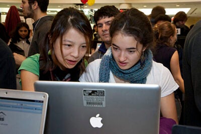 Kathleen Tang '12 (left) and Anna Trowbridge '12 check out one of the projects included in the CS 50 Fair, which had entries from 380 students and attracted 1,000 visitors.