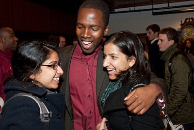 Nworah Ayogu, first marshal of the Class of 2010 (center), gets a hug of mutual congratulations from Rashmi Jasrasaria '10 (left), and and Jyoti Jasrasaria '12 following the midyear graduation ceremony, which was held in the Radcliffe Gymnasium. 