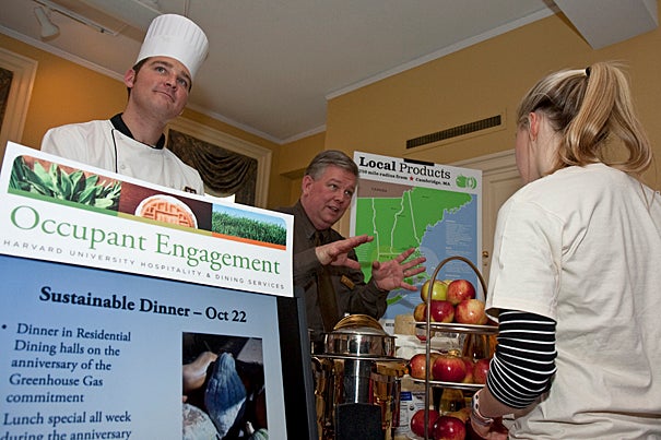 Chef Brian Corcoran (left) and Harvard Dining Services buyer John Aiken staff the local foods table during a green fair at Dudley House in December.