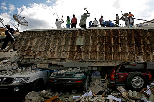 People search for survivors under the rubble of a collapsed building after an earthquake hit Port-au-Prince, Haiti. Groups of experts and medical personnel affiliated with Harvard University, which has several institutional ties to the country, have mobilized to assist the devastated region.