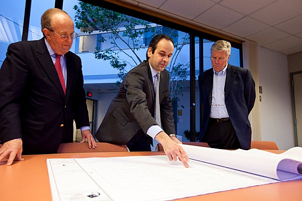 Earthwatch CEO Ed Wilson (center) goes over plans for the new headquarters with architect Jeffrey Brown (left) and Thomas Nicholson (right), a member of Earthwatch's board of directors. The nonprofit environmental group will reside at 114 Western Ave. in Allston, Mass.