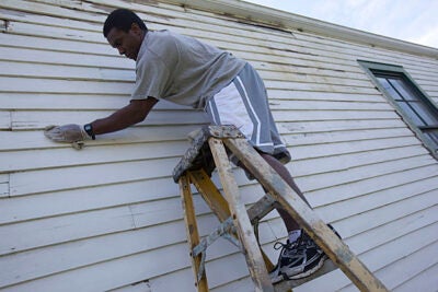 Former Crimson running back Clifton Dawson '07 joined other Harvard alumni as he worked with the Phillips Brooks House Association during its Alternative Spring Break program. Painting a shotgun-style house the size of a rail car, Dawson said,  “It’s a small house, but it’s a big job.” 

