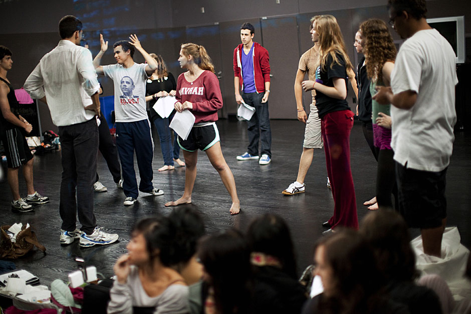 Ben Silva '14 (arms in air) runs lines with his fellow cast members. Stephanie Mitchell/Harvard Staff Photographer