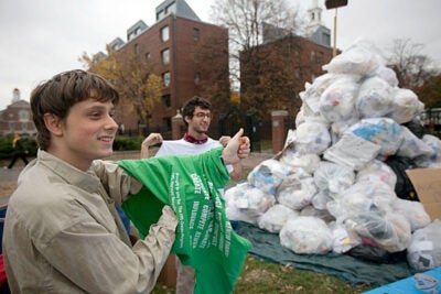 Brandon Geller '08 (left) and Sam Arnold '14 stand beside Mount Trashmore in front of the Science Center. One day every fall, students and staff construct the pile, which represents one day’s trash from Harvard Yard. 