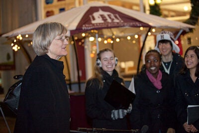 Dozens of staff, faculty, and students — along with local business owners and President Drew Faust (left) — turned out at Forbes Plaza to kick off Crimson Shops Local, an annual effort by the University and the Harvard Square Business Association to encourage shopping nearby for the holidays. Among the performers, Harvard's LowKeys (right).