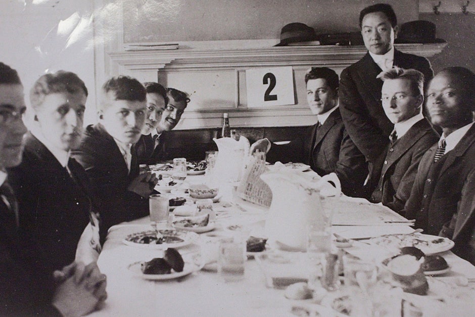 Liberian student Plenyono Gbe Wolo, A.B. 1917 (far right), was the first Harvard College student from the African continent. He is seated at the “cosmopolitan table” inside Foxcroft Hall at a Randall Hall Association meeting in 1914. Credit: Harvard University Archives, call # HUD 3404