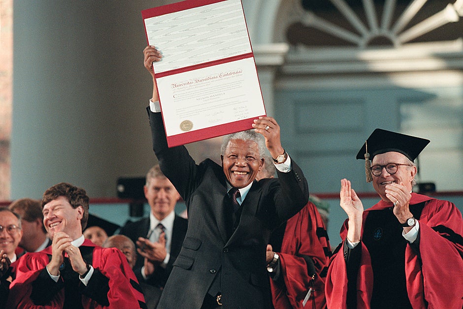 Sept. 18, 1998. South African President Nelson Mandela holds aloft his honorary degree at a special convocation at Harvard. Professor Jeffrey Sachs (left) and University Marshal Richard M. Hunt (right) join in the applause. Photo by Mike Quan