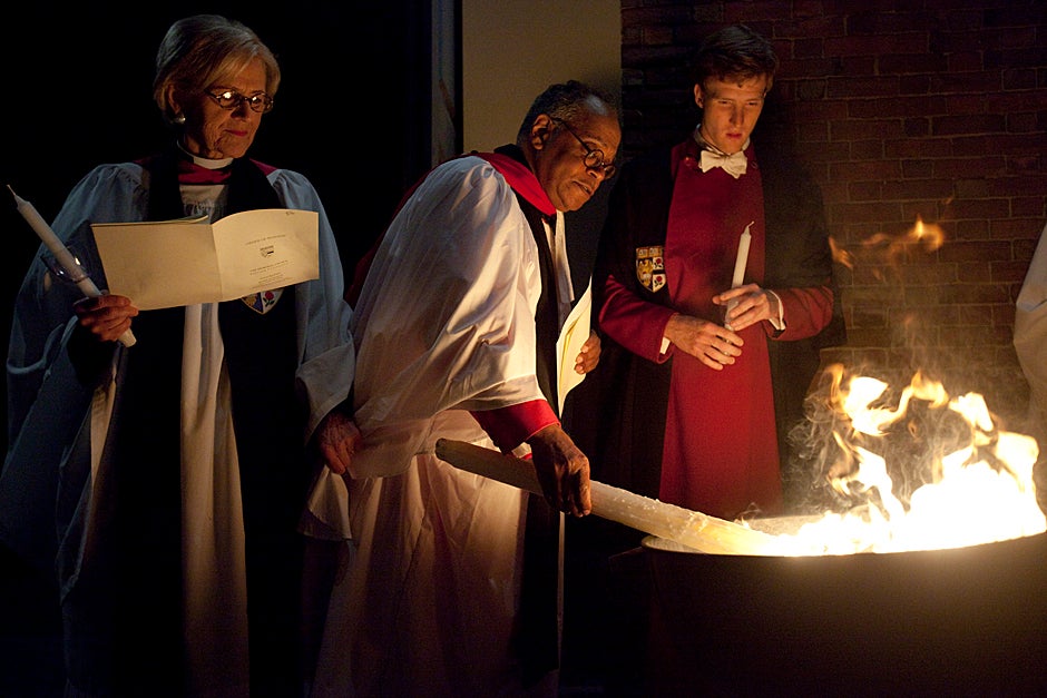 April 3, 2010. Dorothy Austin (from left), Sedgwick Associate Minister in the Memorial Church; Peter J. Gomes, Plummer Professor of Christian Morals and Pusey Minister in the Memorial Church; and Martin Wallner ’11, verger, light candles from a bonfire during the Great Vigil of Easter at the Memorial Church. Photo by Kris Snibbe/Harvard Staff Photographer 