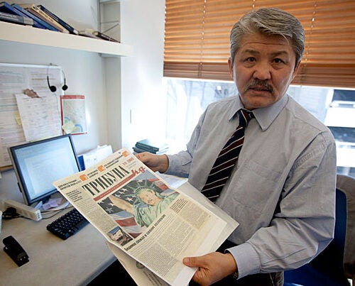 Historian Baktybek “Bakyt” Beshimov, a 2010-2011 fellow in Harvard’s Scholars at Risk program, holds a newspaper from his native Kyrgyzstan in his office at the Davis Center for Russian and Eurasian Studies. It featured him dressed as the Statue of Liberty — a “spy for the West” — at a time when his opposition political views put his life at risk.