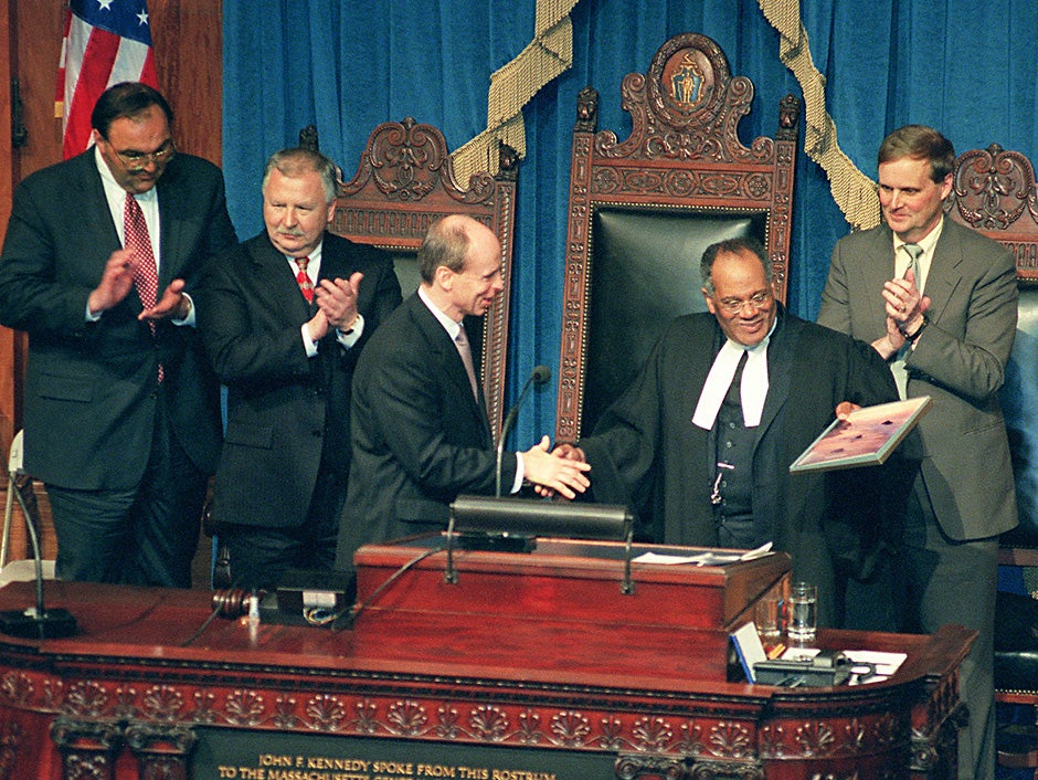 Rev. Peter J. Gomes addresses the Massachusetts House of Representatives in 2000 as part of Speaker of the House Thomas M. Finneran's Lyceum series, which brings special guests before the House to present their thoughts on a wide range of topics. After speaking eloquently and humorously about "The Common-Wealth and the Civic Imagination: Cherishing the Public Mind," Gomes receives a book from Finneran. Rose Lincoln/Harvard Staff Photographer 