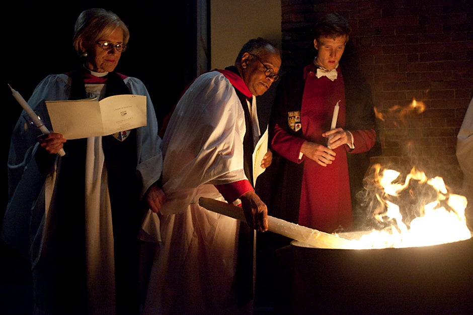 Dorothy Austin (from left), Sedgwick Associate Minister in the Memorial Church; Rev. Peter J. Gomes, Plummer Professor of Christian Morals and Pusey Minister in the Memorial Church; and Martin Wallner '11, verger, light candles from a bonfire during the Great Vigil of Easter at the Memorial Church in April 2010. Kris Snibbe/Harvard Staff Photographer 